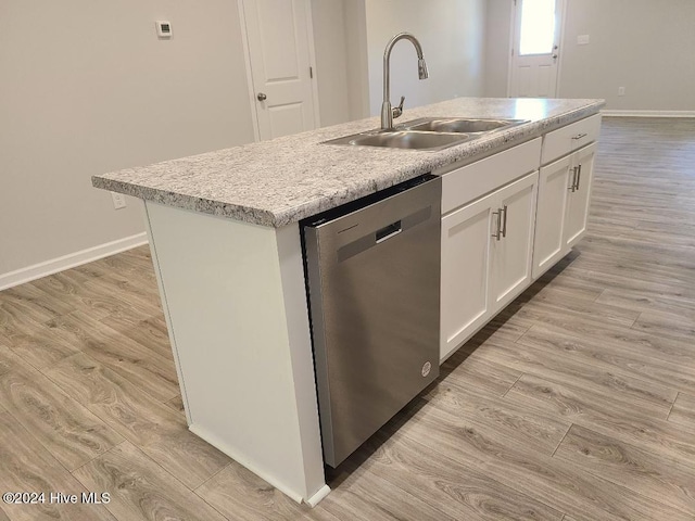 kitchen featuring light wood-type flooring, white cabinets, sink, dishwasher, and an island with sink