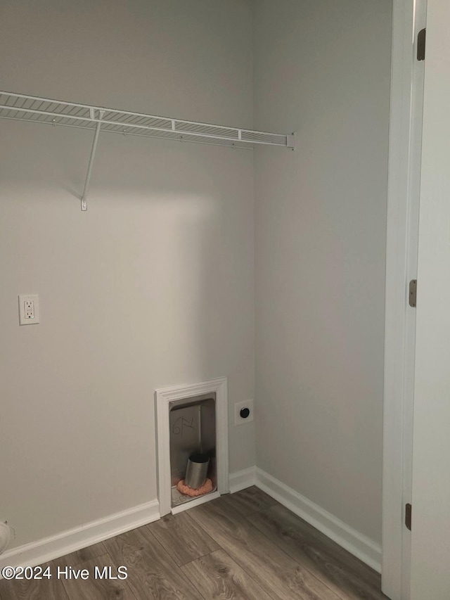 laundry room with electric dryer hookup and dark wood-type flooring