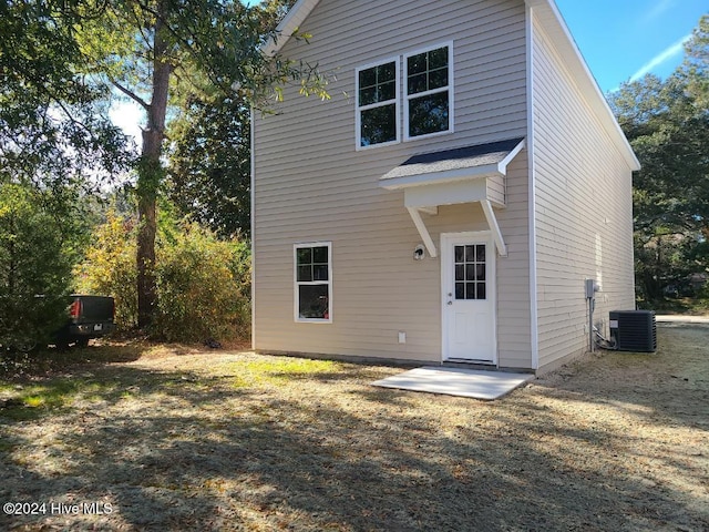 back of house featuring a yard and cooling unit