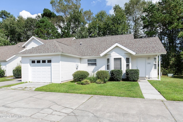 single story home featuring a garage and a front lawn