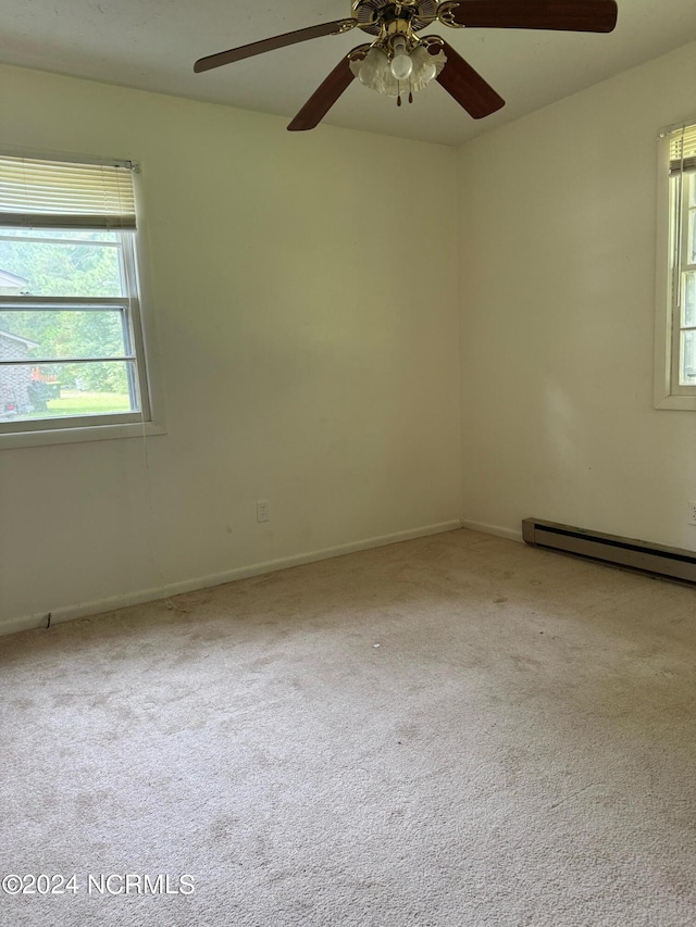 carpeted spare room with ceiling fan and a baseboard radiator