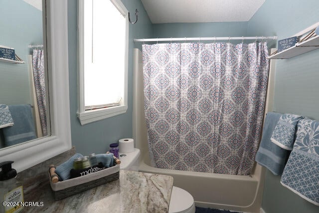 bathroom with shower / bath combo and toilet