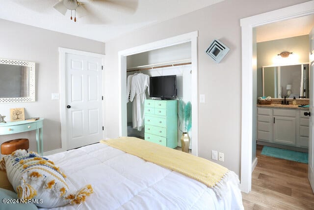 bedroom featuring ceiling fan, light hardwood / wood-style floors, sink, a closet, and ensuite bathroom