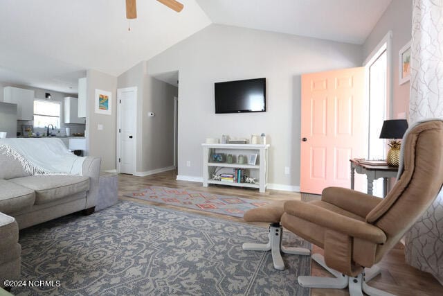 living room featuring ceiling fan, sink, and vaulted ceiling