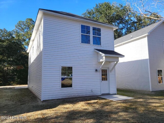 rear view of property with a lawn