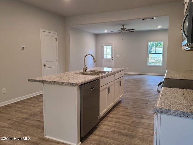 kitchen featuring appliances with stainless steel finishes, dark hardwood / wood-style flooring, sink, a center island with sink, and white cabinetry