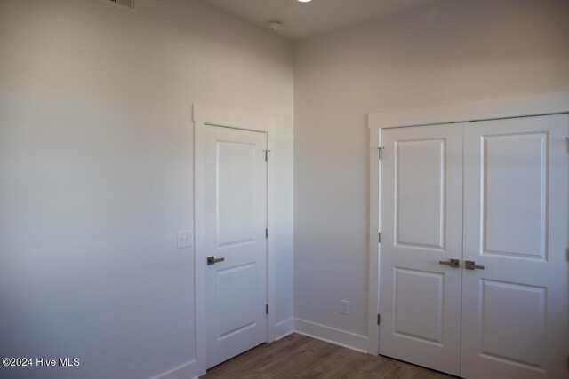 unfurnished bedroom with wood-type flooring and a closet