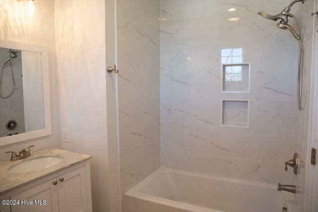 bathroom with vanity and tiled shower / bath