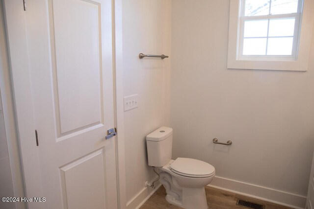 bathroom with hardwood / wood-style floors and toilet