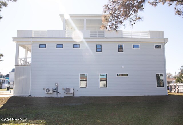 view of property exterior with a lawn and ac unit