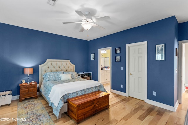 bedroom featuring ensuite bath, ceiling fan, and light wood-type flooring