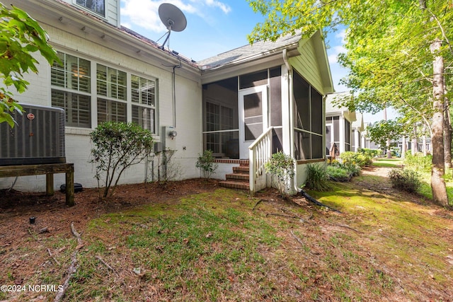 exterior space with central air condition unit and a sunroom