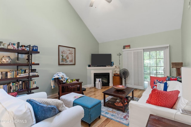 living room with ceiling fan, light hardwood / wood-style flooring, and high vaulted ceiling