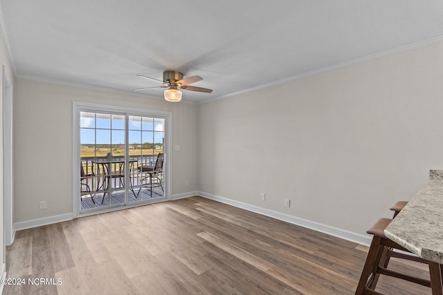 empty room featuring wood-type flooring, ceiling fan, and crown molding