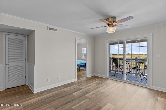 empty room with ceiling fan, light wood-type flooring, and ornamental molding