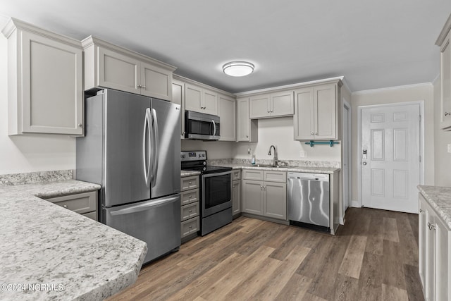 kitchen featuring dark hardwood / wood-style floors, sink, gray cabinetry, appliances with stainless steel finishes, and crown molding