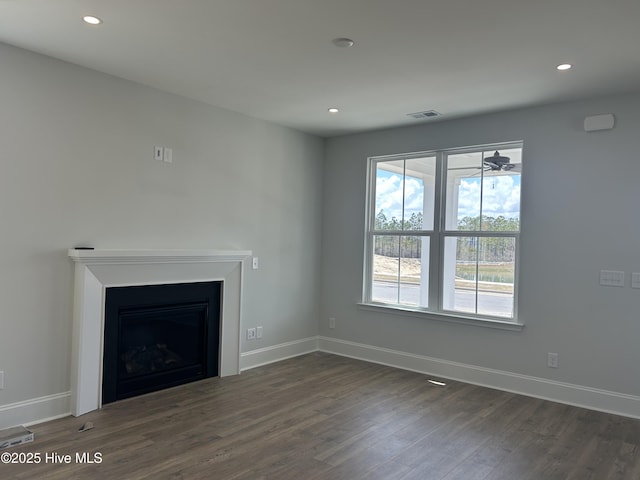 unfurnished living room with recessed lighting, visible vents, baseboards, and dark wood-type flooring