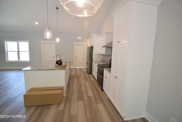 kitchen with black range with electric stovetop, white cabinets, exhaust hood, decorative light fixtures, and stainless steel fridge