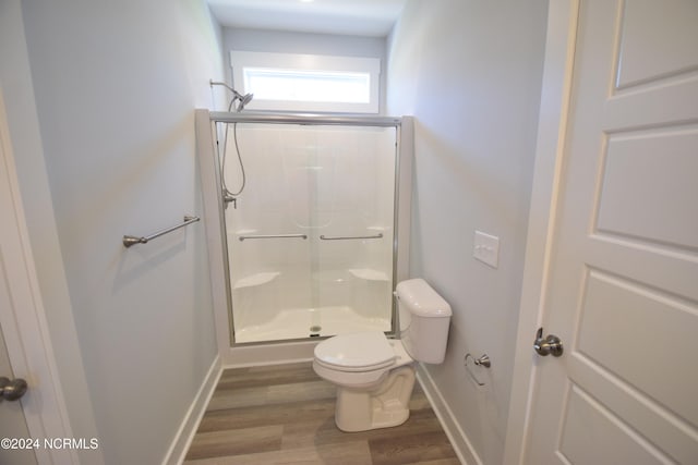 bathroom with wood-type flooring, an enclosed shower, and toilet