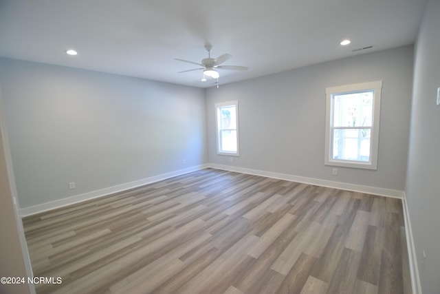 empty room with ceiling fan and light hardwood / wood-style flooring