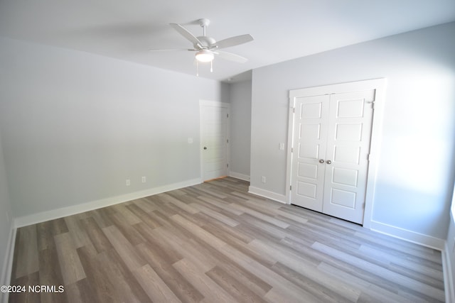 unfurnished bedroom with light hardwood / wood-style floors, ceiling fan, and a closet