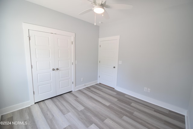 unfurnished bedroom with ceiling fan, a closet, and light wood-type flooring