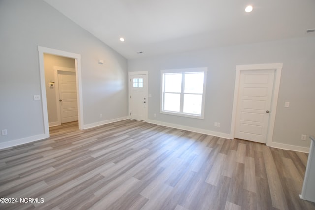 unfurnished room featuring light hardwood / wood-style flooring and vaulted ceiling