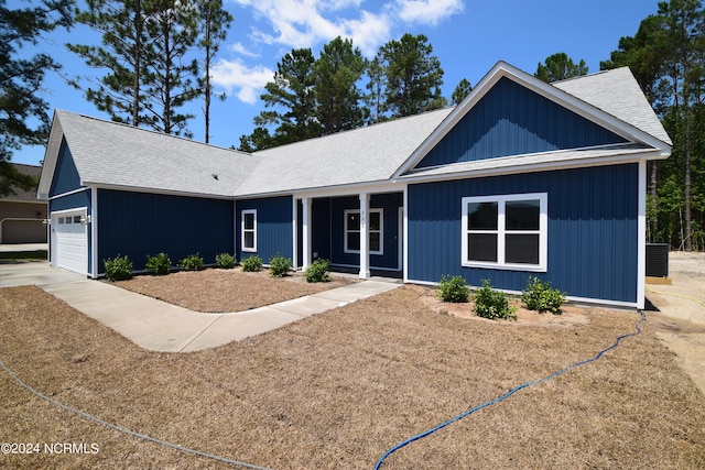 single story home featuring a garage and central air condition unit