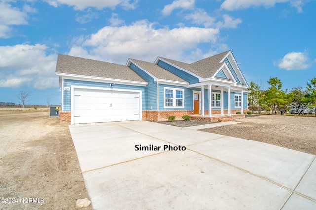 view of front of home with central AC unit and a garage