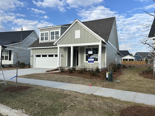 view of front of house featuring central AC, a porch, a garage, and a front lawn