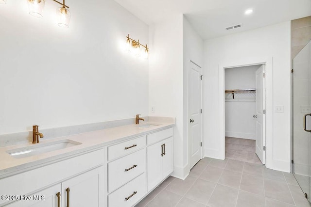 bathroom with tile patterned flooring, a shower stall, visible vents, and a sink