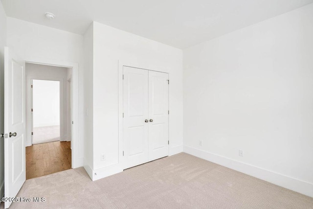 unfurnished bedroom featuring a closet, carpet flooring, and baseboards