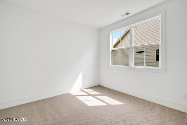 empty room with visible vents, baseboards, and carpet floors