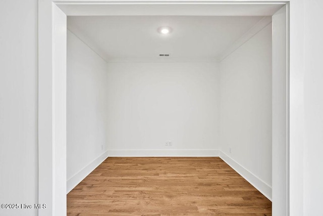 unfurnished room with visible vents, light wood-type flooring, and baseboards