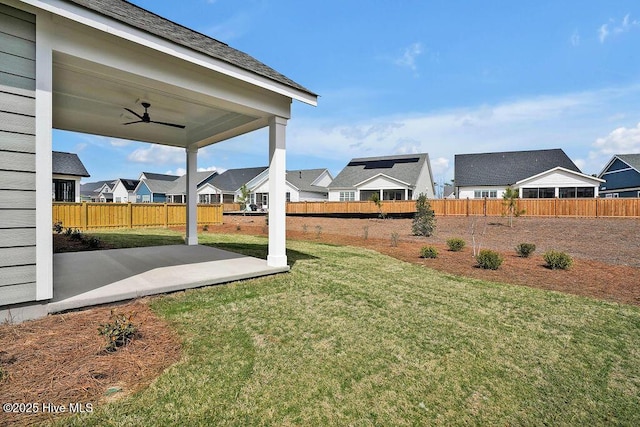 view of yard with a patio, fence, a residential view, and ceiling fan