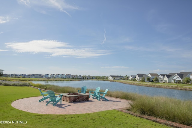 view of patio / terrace featuring a residential view, a fire pit, and a water view