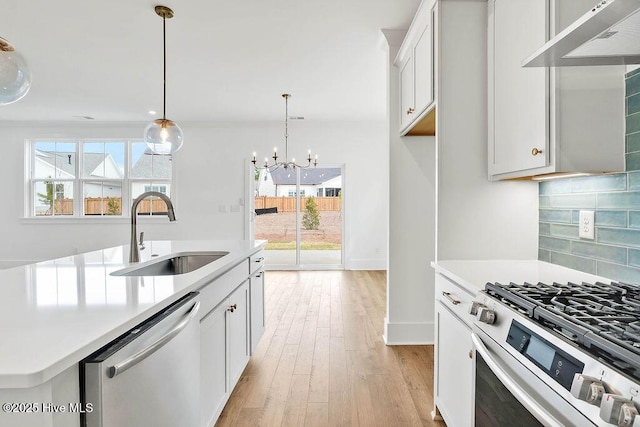 kitchen featuring a sink, gas range oven, dishwasher, tasteful backsplash, and a wealth of natural light