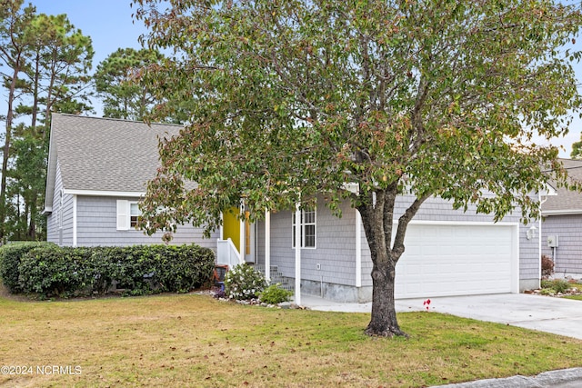 view of property hidden behind natural elements with a front yard and a garage