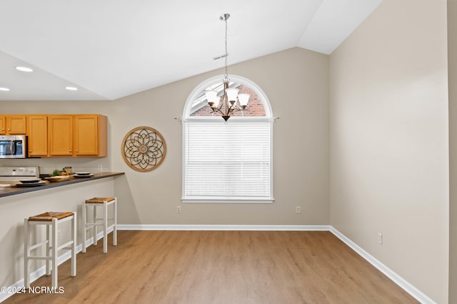 kitchen featuring pendant lighting, lofted ceiling, an inviting chandelier, white electric stove, and light wood-type flooring