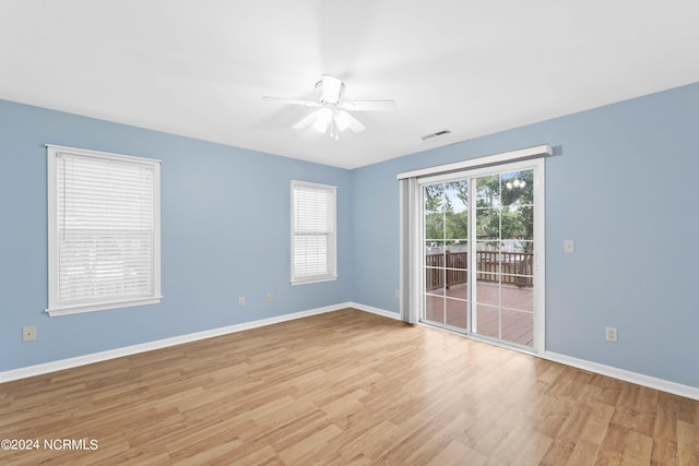unfurnished room with baseboards, ceiling fan, wood finished floors, and visible vents