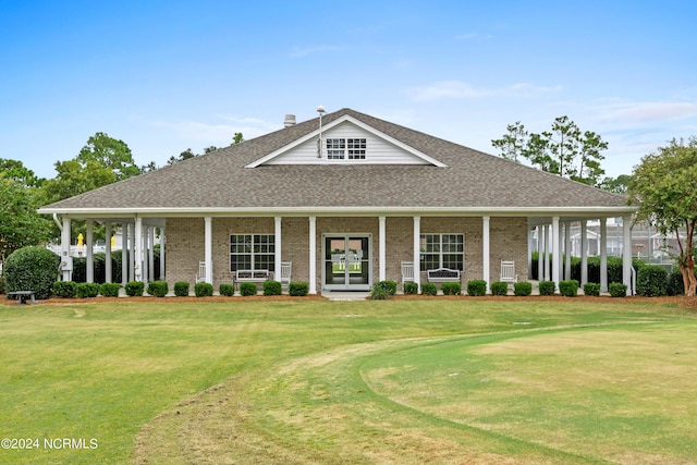 country-style home featuring french doors, a shingled roof, a front lawn, and brick siding