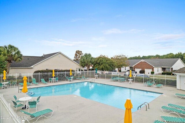 community pool featuring fence and a patio