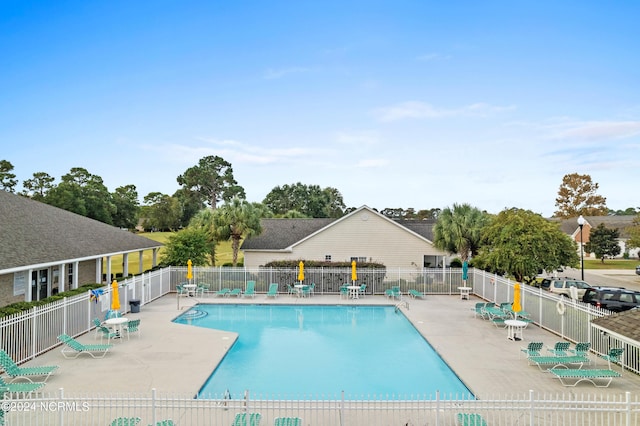 community pool featuring a patio and fence