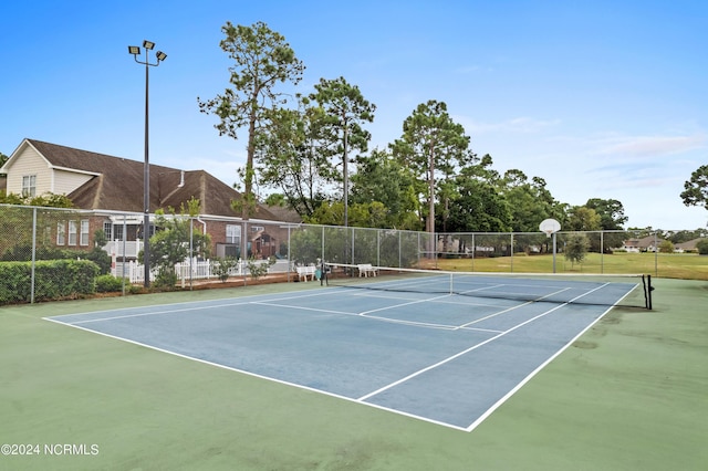 view of tennis court featuring fence and community basketball court