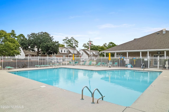 community pool with fence and a patio area