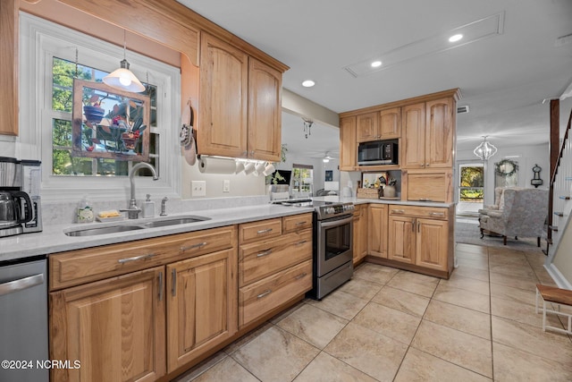 kitchen featuring sink, a notable chandelier, pendant lighting, light tile patterned floors, and appliances with stainless steel finishes