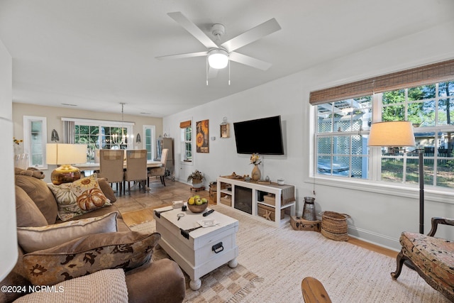 living room with ceiling fan with notable chandelier