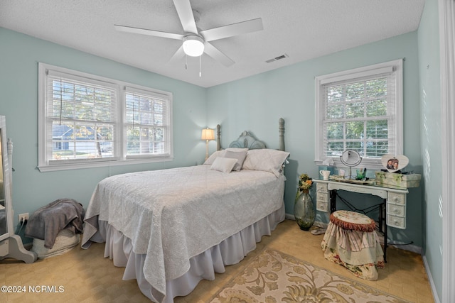 bedroom with a textured ceiling and ceiling fan