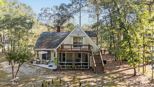 rear view of house featuring a sunroom, a patio area, and a deck