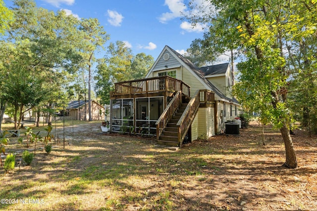 rear view of house featuring a sunroom, central AC unit, and a deck